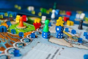 Board game concept- many board game field figures, meeple, dice and coins